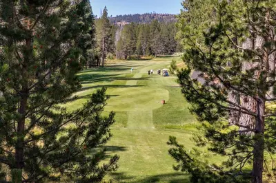 a view of a golf course through the trees at Welcoming Tahoe-Donner Cabin in Truckee