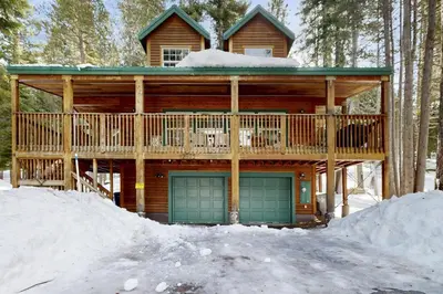 a log cabin with a garage in the snow at Welcoming Tahoe-Donner Cabin in Truckee