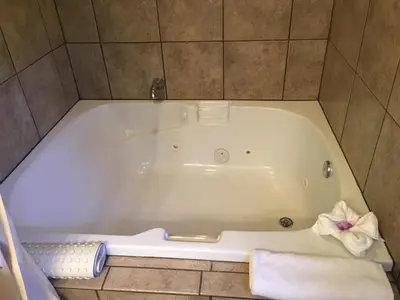 a bath tub in a bathroom with a towel at Pepper Tree Inn Tahoe City in Tahoe City