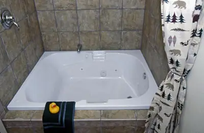 a bath tub in a bathroom with a shower curtain at Pepper Tree Inn Tahoe City in Tahoe City