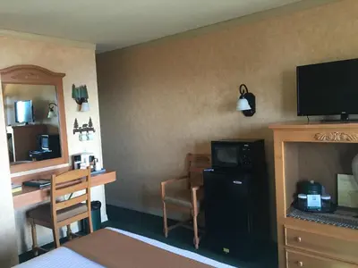 a hotel room with a desk and a television and a room at Pepper Tree Inn Tahoe City in Tahoe City