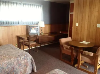 a hotel room with a bed and a table and a television at Bridgeport Inn in Bridgeport