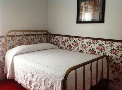 a bedroom with a bed with a floral wallpaper at Bridgeport Inn in Bridgeport