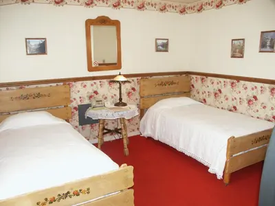 two beds in a room with a mirror and a table at Bridgeport Inn in Bridgeport