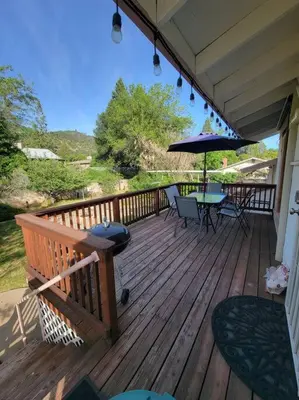 a wooden deck with a table and an umbrella at Becky's Condo in Mariposa