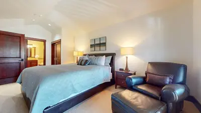 a bedroom with a bed and a chair at Juniper Crest #25 Condo in Mammoth Lakes