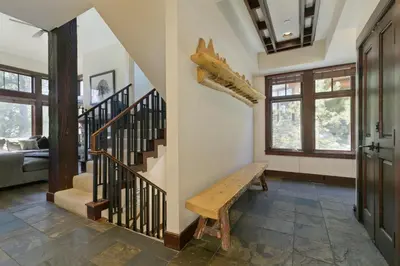 a living room with a staircase and a wooden bench at Juniper Crest #25 Condo in Mammoth Lakes