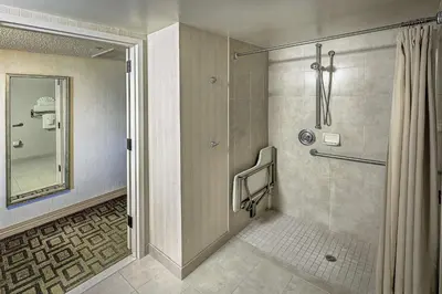 a bathroom with a shower with a glass door at Hilton Sacramento Arden West in Sacramento