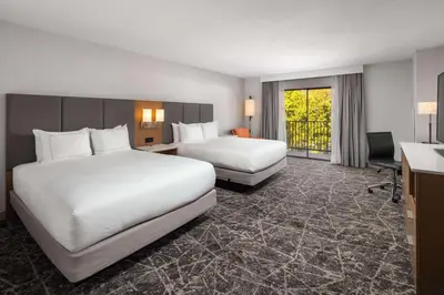 a hotel room with two beds and a desk at DoubleTree By Hilton Sacramento in Sacramento