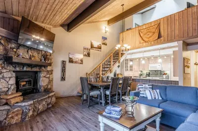 a living room with a blue couch and a fireplace at Mountainback 80 in Mammoth Lakes