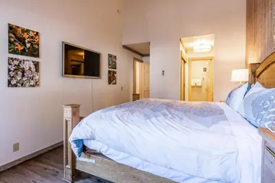a bedroom with a bed and a tv on the wall at Mountainback 80 in Mammoth Lakes