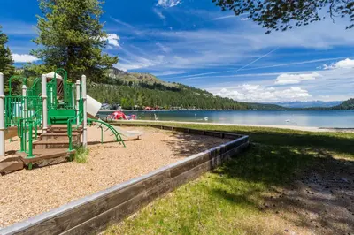 a playground on a beach next to a body of water at The Acorn House in Truckee