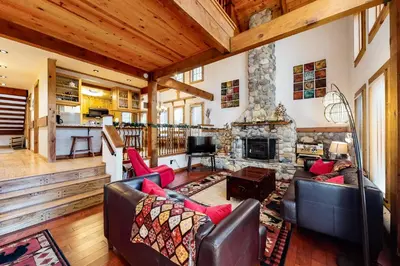a living room with two couches and a stone fireplace at The Acorn House in Truckee