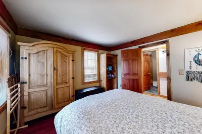 a bedroom with a bed and wooden walls at The Acorn House in Truckee