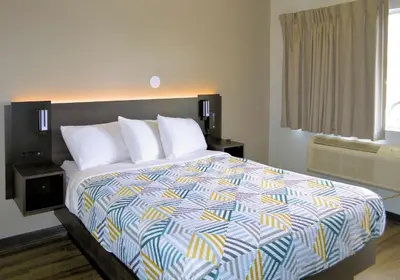 a bedroom with a large bed with a colorful comforter at Motel 6-Reno, NV - Livestock Events Center in Reno