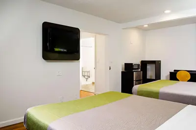 a hotel room with two beds and a tv on the wall at Motel 6-Modesto, CA - Downtown in Modesto
