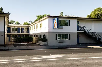 a white building with a sign on the side of it at Motel 6-Modesto, CA - Downtown in Modesto
