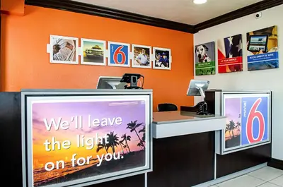 an office with an orange wall and a desk with a sign at Motel 6-Modesto, CA - Downtown in Modesto