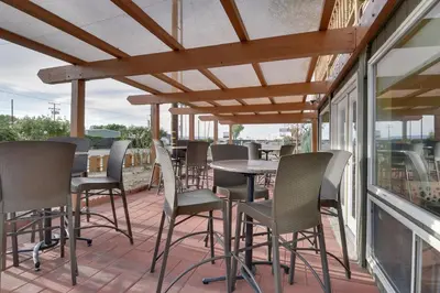 a patio with chairs and tables on a balcony at Vagabond Inn Bishop in Bishop