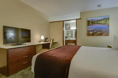 a hotel room with a bed and a flat screen tv at Vagabond Inn Bishop in Bishop