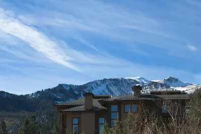 a house with a mountain in the background at Aspen Creek by 101 Great Escapes in Mammoth Lakes