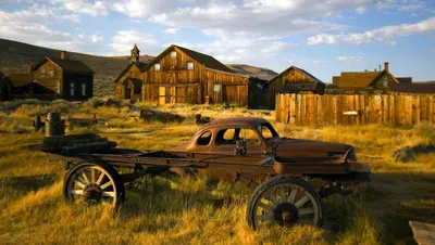 an old truck parked in a field in front of a house at Ruby Inn Bridgeport in Bridgeport