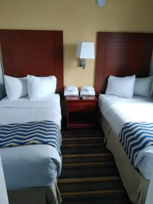 a hotel room with two beds and a lamp at Travelodge by Wyndham Bishop in Bishop