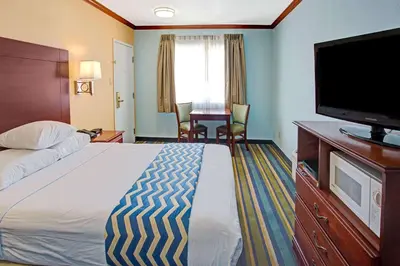 a hotel room with a bed and a flat screen tv at Travelodge by Wyndham Bishop in Bishop