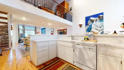a kitchen with white cabinets and a staircase at Snowcreek Iii #420 Condo in Mammoth Lakes