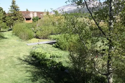 a garden with a wooden bridge in a field at Snowcreek Iii #420 Condo in Mammoth Lakes