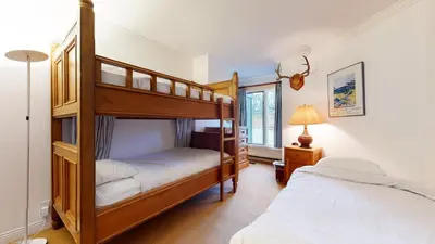 a bedroom with two bunk beds and a window at Snowcreek Iii #420 Condo in Mammoth Lakes