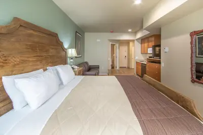a bedroom with a large bed with a wooden headboard at Holiday Inn Club Vacations - David Walley's Resort in Genoa