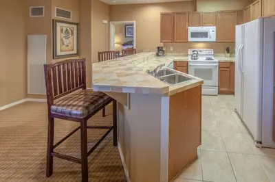 a kitchen with a counter and a sink and a refrigerator at Holiday Inn Club Vacations - David Walley's Resort in Genoa