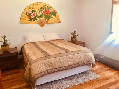 a bedroom with a bed with a painting on the wall at A Lovely Cabin House at Way Woods Retreat with Outdoor Hot Tub! - By Sacred Hub MGMT in Foresthill