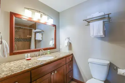 a bathroom with a sink and a toilet and a mirror at Chateau Blanc 23 in Mammoth Lakes