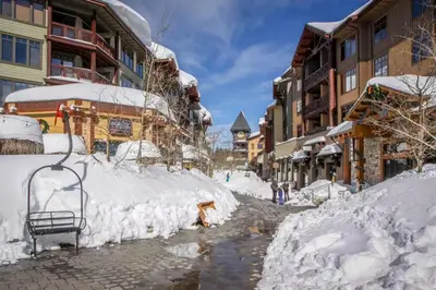 a street covered in snow next to buildings at Chateau Blanc 23 in Mammoth Lakes