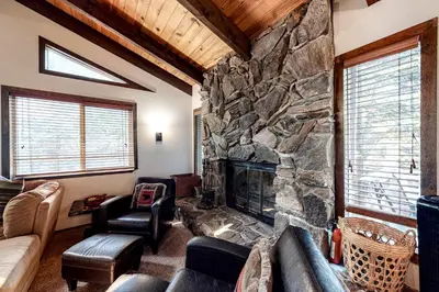 a living room with a large stone fireplace at Cherry Retreat in South Lake Tahoe