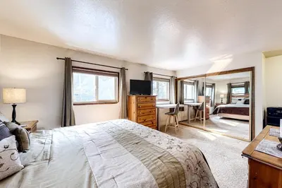 a bedroom with a bed and a desk and a mirror at Cherry Retreat in South Lake Tahoe