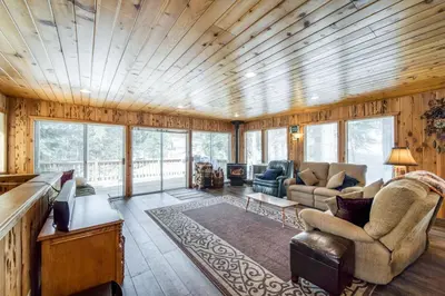 a living room with wooden walls and a wooden ceiling at Tamarack Dream in Lakeshore