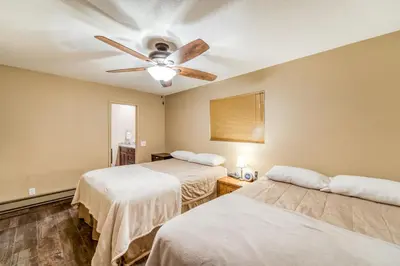 a room with two beds and a ceiling fan at Tamarack Dream in Lakeshore