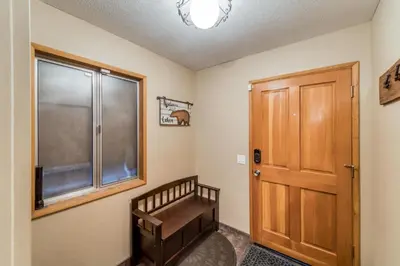 a room with a wooden door and a window at Tamarack Dream in Lakeshore