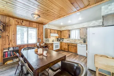 a kitchen with a table and a refrigerator at Tamarack Dream in Lakeshore