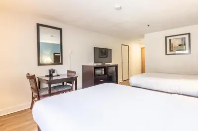 a hotel room with two beds and a desk with a television at Quality Inn near Mammoth Mountain Ski Resort in Mammoth Lakes