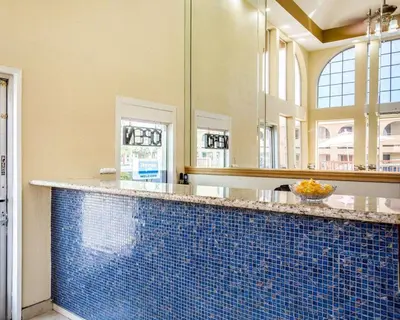 a bathroom with a blue tiled counter with mirrors at Rodeway Inn Delano in Delano
