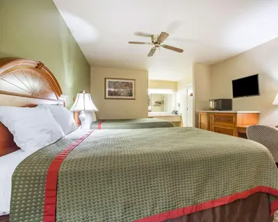 a bedroom with a large bed with a ceiling fan at Rodeway Inn Delano in Delano