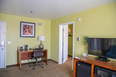 a room with a desk and a television and a chair at Quality Inn Merced Gateway to Yosemite in Merced