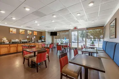 a dining room with tables and chairs in a restaurant at Comfort Suites Visalia - Convention Center in Visalia