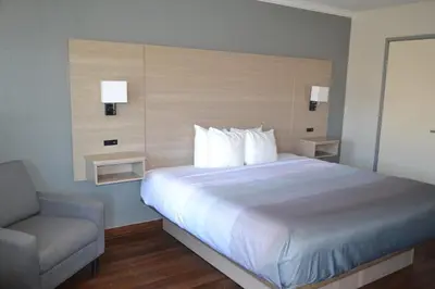 a bedroom with a large bed and a chair at Quality Inn Bishop near Mammoth in Bishop
