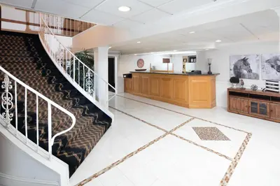 an empty lobby with a staircase and a counter at Red Lion Inn & Suites Auburn in Auburn