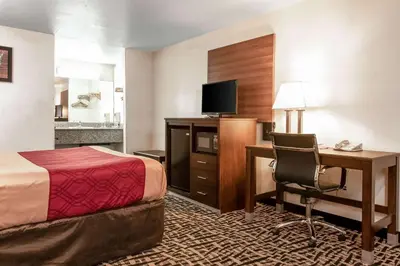 a hotel room with a bed and a desk with a computer at Executive Inn westley,CA in Westley